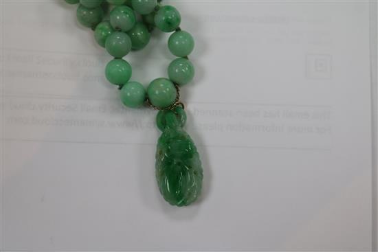 A double strand graduated jadeite bead necklace with carved jadeite pendant, pendant 29mm.